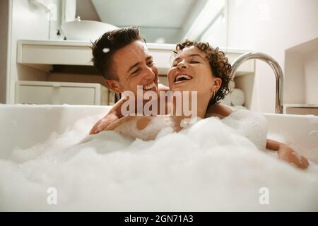 Couple de reines gaies appréciant se baigner ensemble à la maison. Un jeune couple heureux s'amuser dans la baignoire. Romantique jeune couple LGBTQ+ dépenser la qualité t Banque D'Images