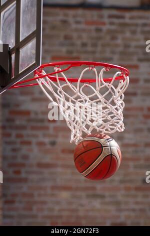 Basket-ball Ring le ballon tombe à travers le Hoop Banque D'Images