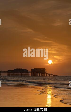 Vue sur le coucher du soleil sur la jetée de Cromer montrant l'extrémité du théâtre de la jetée et la station de bateau de sauvetage RNLI, Cromer, Norfolk, Royaume-Uni Banque D'Images