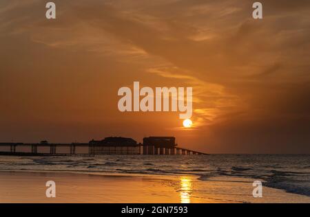 Vue sur le coucher du soleil sur la jetée de Cromer montrant l'extrémité du théâtre de la jetée et la station de bateau de sauvetage RNLI, Cromer, Norfolk, Royaume-Uni Banque D'Images