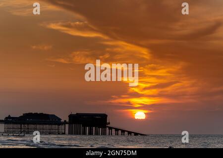 Vue sur le coucher du soleil sur la jetée de Cromer montrant l'extrémité du théâtre de la jetée et la station de bateau de sauvetage RNLI, Cromer, Norfolk, Royaume-Uni Banque D'Images