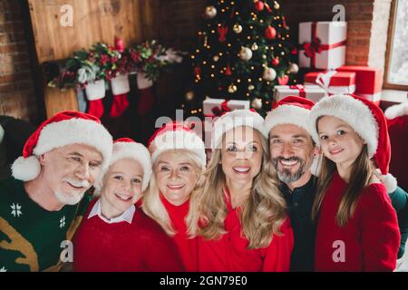 Photo portrait des grands-parents célébrant le nouveau yer avec des enfants portant la casquette rouge souriant ensemble esprit de Noël Banque D'Images