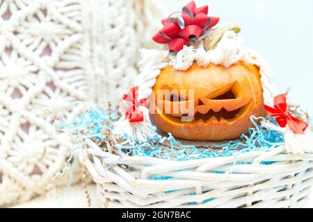 Citrouille amusante avec des tresses et un noeud dans un panier. Lanterne de Jack. Halloween insolite, humour. Banque D'Images