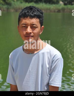 Portrait d'un jeune homme Ladakhi (Indien du Nord) regardant l'appareil photo et se tenant à côté du lac Banque D'Images