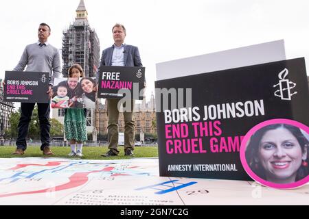 Richard Ratcliffe proteste sur la place du Parlement avec sa fille et le responsable britannique d'Amnesty international Banque D'Images