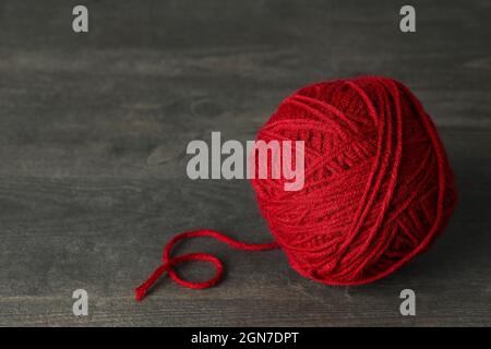 Boule de fil rouge sur table en bois gris Banque D'Images