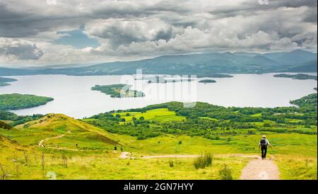 Vue sur le Loch Lomond depuis la West Highland Way en Écosse. Un randonneur marchant sur le chemin vers le lac. Banque D'Images