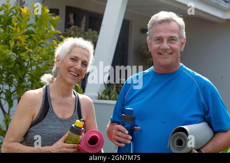 Joyeux couple caucasien senior tenant des tapis de yoga et regardant la caméra Banque D'Images