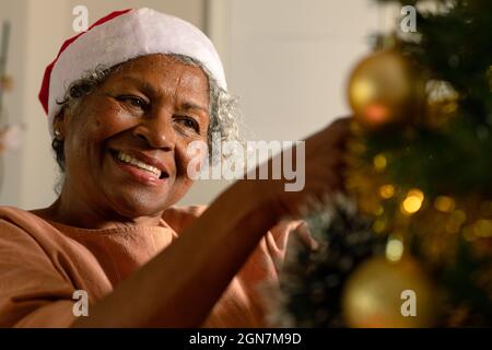 Bonne femme africaine américaine senior décorant l'arbre de noël Banque D'Images