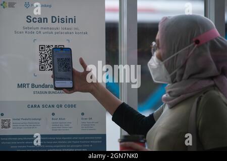 (210923) -- JAKARTA, 23 septembre 2021 (Xinhua) -- Une femme scanne le code QR avec une application mobile comme condition pour utiliser les transports publics pendant la pandémie COVID-19 à Jakarta, Indonésie, 23 septembre 2021. Le nombre de cas de COVID-19 en Indonésie a augmenté de 2,881 en un jour, passant à 4,201,559, le nombre de décès ajoutant de 160 à 141,114, a déclaré jeudi le ministère de la Santé du pays. (Xinhua/Veri Sanovri) Banque D'Images