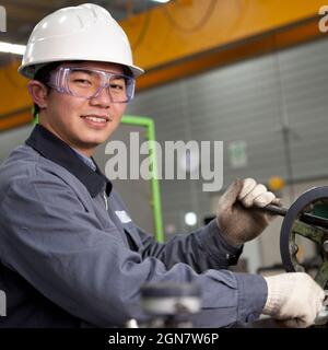 Opérateur de machine industrielle moderne travaillant en usine Banque D'Images