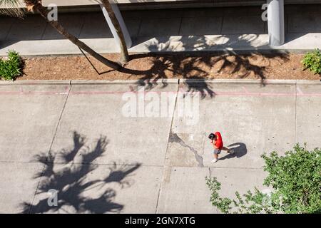 LA NOUVELLE-ORLÉANS, LA, États-Unis - 10 JUIN 2021 : homme seul marchant avec des ombres au milieu de la rue Banque D'Images