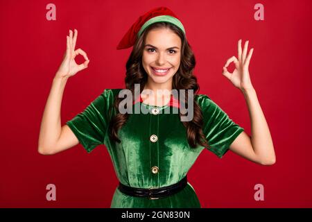 Photo d'une jeune femme charmante et excitée vêtue d'un costume d'orf souriant montrant des signes d'okey isolé de couleur rouge arrière-plan Banque D'Images