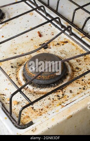 une cuisinière sale ou cuisinière à gaz dans la cuisine, surface couverte de taches avec des restes de nourriture, brûleur non nettoyé fermé Banque D'Images