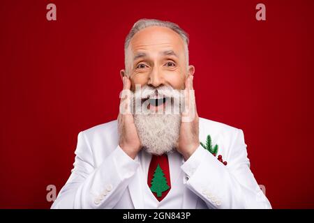 Photo de l'âge assez impressionné gentleman porter nouveau costume de l'année souriant bras joues isolé couleur rouge arrière-plan Banque D'Images