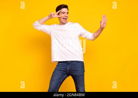 Photo portrait brunet Guy dans une tenue décontractée se glaçant sur la danse des vacances surjoyed isolé couleur jaune vif fond Banque D'Images