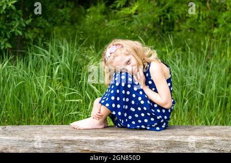 triste fille blonde assise à banc Banque D'Images
