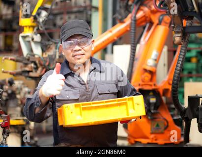 Travailleur tenant la boîte jaune avec le pouce Banque D'Images