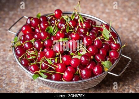 Cerises dans un tamis en acier. Vue de dessus, texture Banque D'Images