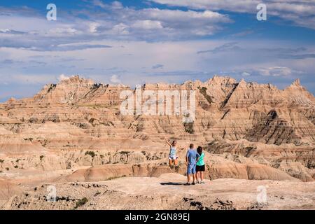 Famille prenant des photos de fille sautant à la vallée de White River dans le parc national de Badlands, Dakota du Sud. Banque D'Images