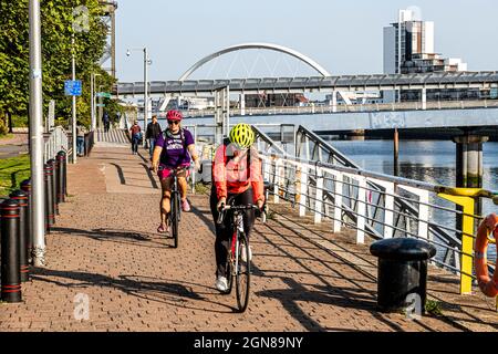 Cyclistes à côté du Scottish Event Campus SEC devant Bells Bridge au-dessus de la rivière Clyde à Glasgow, en Écosse, Royaume-Uni Banque D'Images