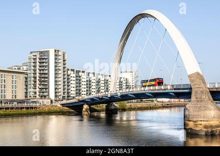 Un bus passant par le Clyde Arc Bridge connu localement sous le nom de Squinty Bridge au-dessus de la rivière Clyde à Glasgow, en Écosse au Royaume-Uni Banque D'Images