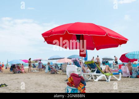 ALCOSSEBRE, ESPAGNE - 22 septembre 2021 : Communauté Valencienne, Espagne - août 2021. Scène d'été à la plage. Parapluie rouge. Banque D'Images