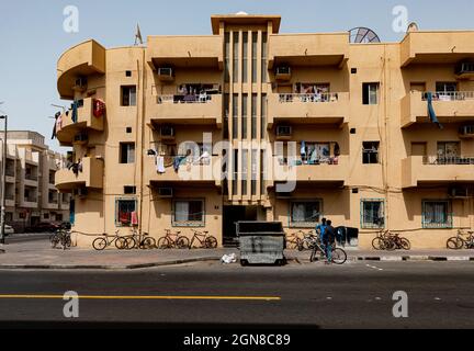 DUBAÏ, Émirats Arabes Unis - 5 SEPTEMBRE 2018 : les hommes bavardant à l'extérieur d'un ancien bâtiment résidentiel de Deira le 5 septembre 2018 à Dubaï, Émirats Arabes Unis Banque D'Images