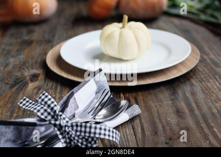 Couverts le jour de Thanksgiving table de vacances buffle carreaux serviette nouée avec un noeud noir et blanc. Mise au point sélective sur pour et cuillère Banque D'Images