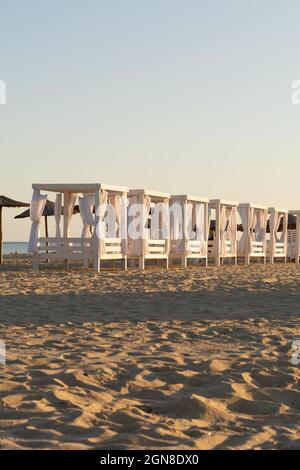 Tentes de plage dans les rayons du soleil couchant, scène de plage Banque D'Images