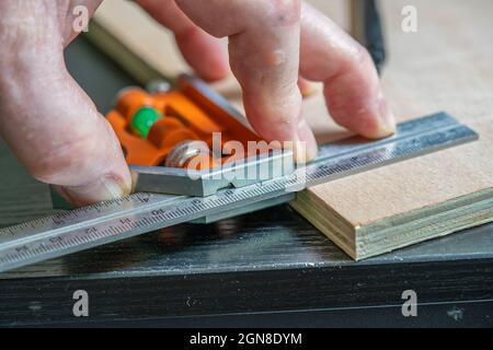 objectif choisi de mesurer un angle droit parfait sur un morceau de contreplaqué à l'aide d'un carré calibré réglable Banque D'Images