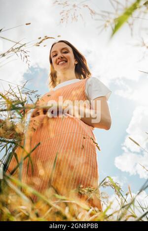 Femme souriante debout sur l'herbe Banque D'Images