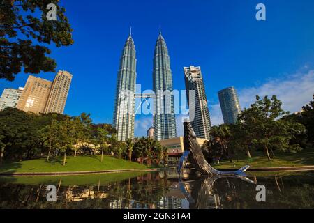 Malaisie, Kuala Lumpur, sculpture sur l'étang et les baleines dans le parc KLCC avec Petronas Towers en arrière-plan Banque D'Images