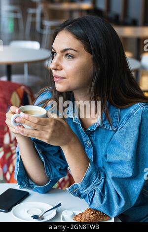 Femme pensive freelance travailleur ayant un café au café Banque D'Images