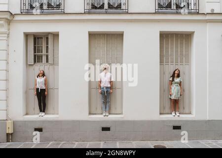 Groupe multiethnique d'amis hommes et femmes devant le mur Banque D'Images