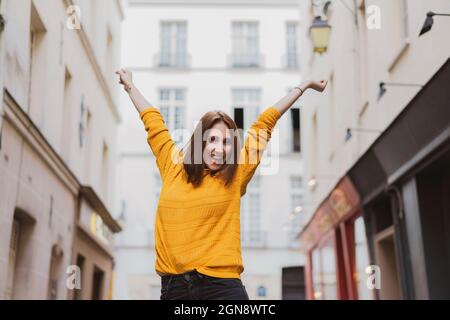 Jeune femme joyeuse debout avec les bras levés Banque D'Images
