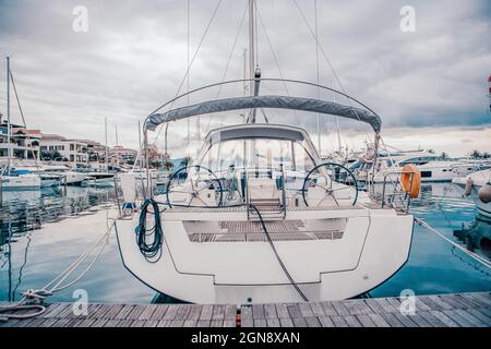 Yacht blanc sur le quai dans le port par jour nuageux, vue de la poupe. Photo de haute qualité Banque D'Images