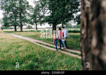 Les parents marchent avec leurs filles sur le sentier du parc Banque D'Images
