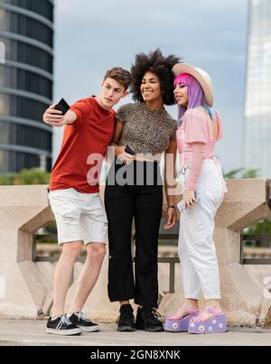Jeune homme prenant le selfie avec des amis féminins Banque D'Images