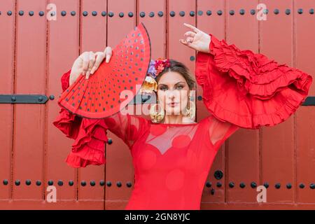 Danseuse de flamenco féminine dansant en face de la porte rouge Banque D'Images