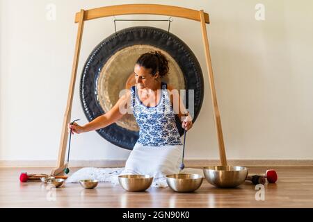 Femme sonothérapeute jouant percussion instrument en studio Banque D'Images