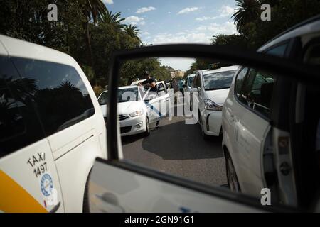 Malaga, Espagne. 23 septembre 2021. Un chauffeur de taxi vu se reposer devant son taxi alors qu'il participe à la manifestation.les chauffeurs de taxi ont défilé et bloqué les rues principales de Malaga exigeant un contrôle plus élevé sur les véhicules avec permis de conduire (VTC). Malaga est la ville d'Andalousie où il y a plus de licences de voitures VTC. Crédit : SOPA Images Limited/Alamy Live News Banque D'Images