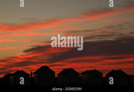 Heacham, Royaume-Uni. 22 septembre 2021. Une personne vue entre des cabanes de plage à une belle fin de la journée juste après le coucher de soleil de l'équinoxe d'automne à Heacham, Norfolk, le 22 septembre 2021 crédit: Paul Marriott/Alamy Live News Banque D'Images
