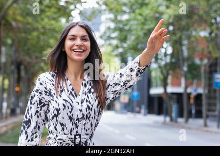 Une belle jeune femme souriante se hante sur la route Banque D'Images