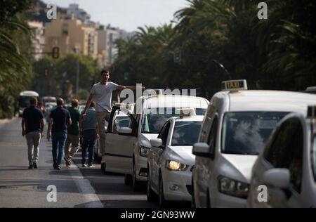 Malaga, Espagne. 23 septembre 2021. Un chauffeur de taxi a vu monter sur sa voiture pendant qu'il participe à la manifestation.les chauffeurs de taxi ont défilé et bloqué les rues principales de Malaga exigeant un contrôle plus élevé sur les véhicules avec permis de conduire (VTC). Malaga est la ville d'Andalousie où il y a plus de licences de voitures VTC. (Photo de Jesus Merida/SOPA Images/Sipa USA) Credit: SIPA USA/Alay Live News Banque D'Images