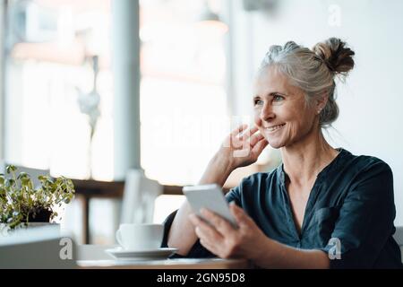 Tablette numérique avec tasse à café et journal sur table dans le café Banque D'Images
