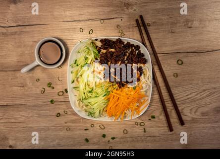 Plat chinois traditionnel, nouilles au porc épicé, légumes et sauce soja Banque D'Images