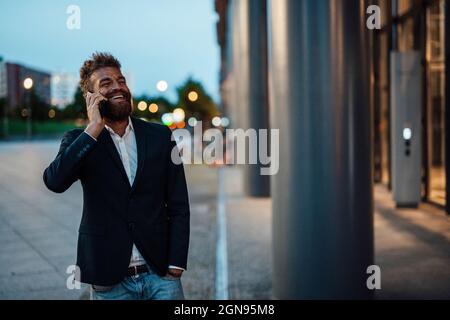 Homme indépendant barbu tenant le smartphone sur la piste Banque D'Images