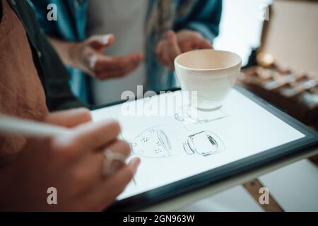 Illustratrice féminine utilisant une tablette graphique lorsqu'elle travaille au bureau à domicile Banque D'Images