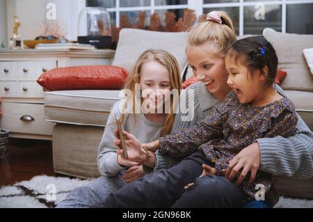 Des filles gaies emportant le selfie à la maison par téléphone portable Banque D'Images